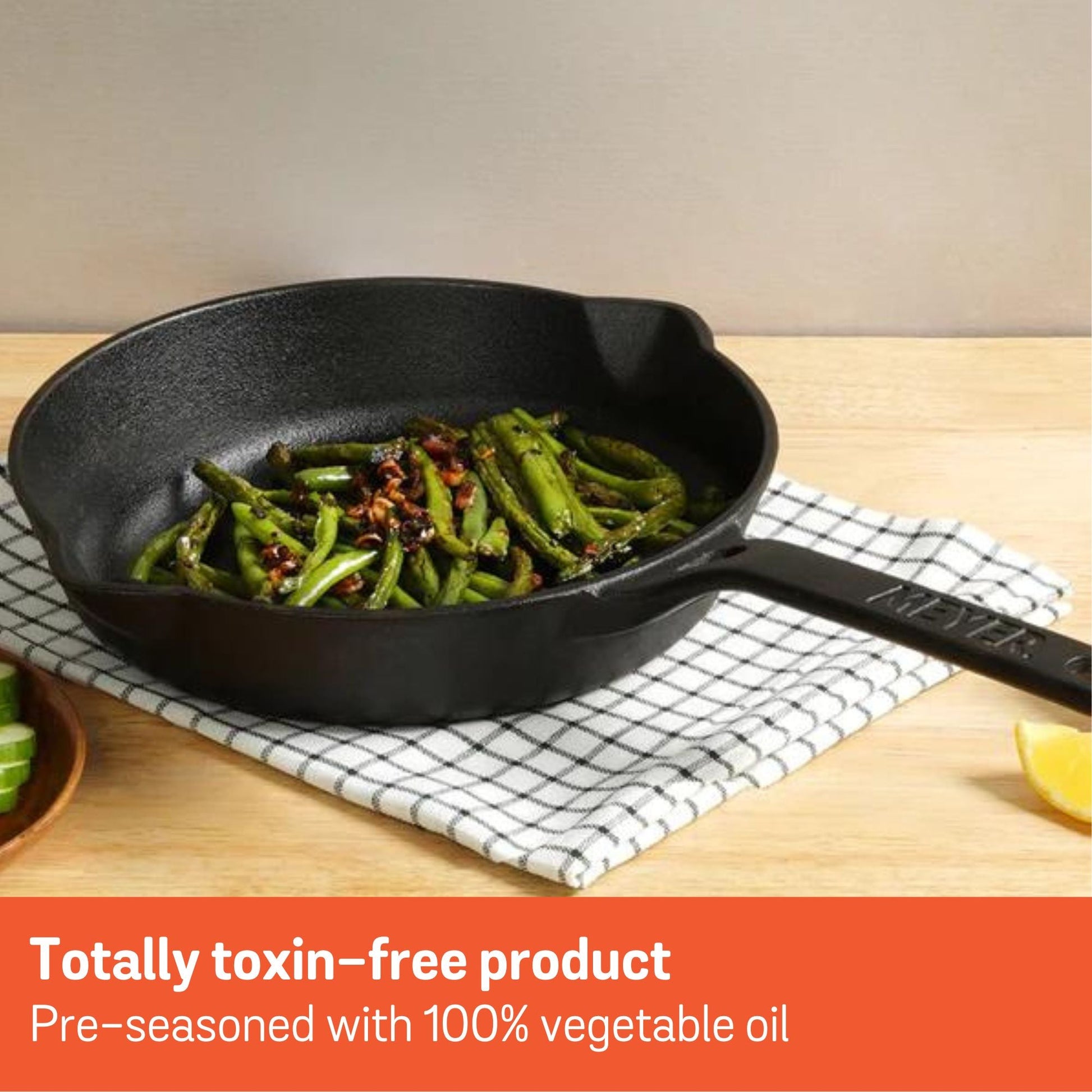 Meyer cast iron skillet with green beans, lemon on wooden surface